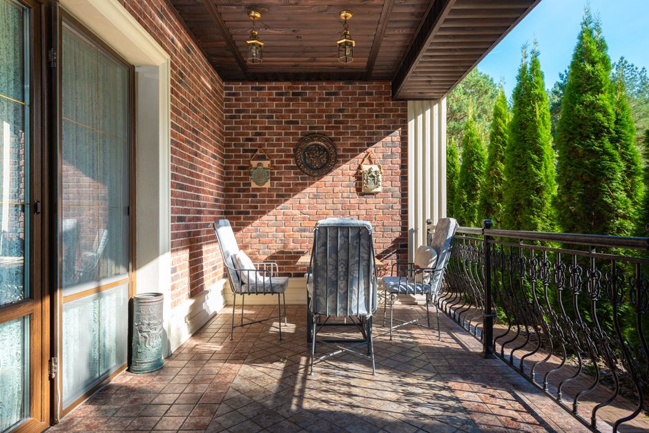 Houten veranda met hergebruikte materialen en planten.